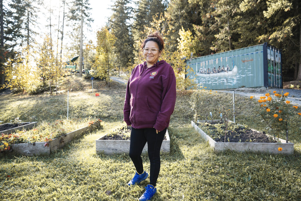 Splatsin community member standing in garden supporting food sovereignty efforts
